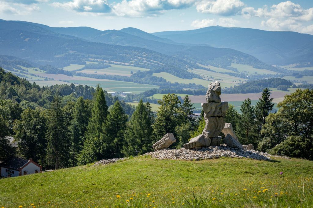 Kamenný pomník na kopci s výhledem do údolí a na hřebeny Jeseníků