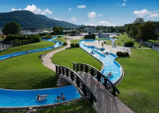 Letecký pohled na venkovní Termální riviéru Terme Čatež s líné řeky, zelení a kopci v pozadí