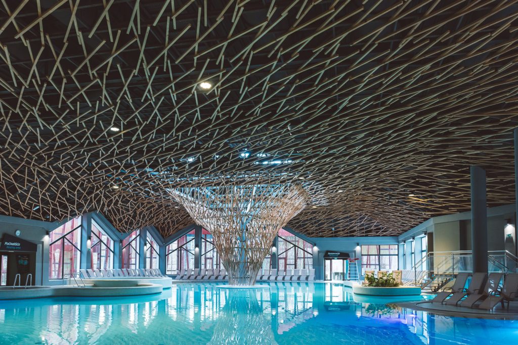 Vnitřní termální bazén s dřevěnou stropní konstrukcí ve wellness centru Terme Olimia